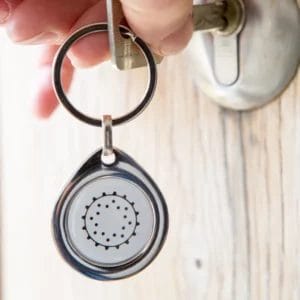Penta Power Pendant als Schlüsselanhänger an Haustürschloss — tragbarer EMF-Schutz transformiert Strahlung in Vitalität