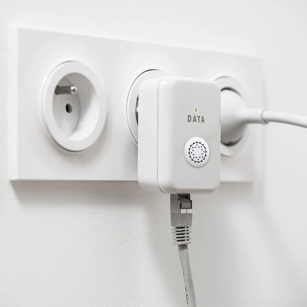 Penta Power Multi Tag op powerline-internetadapter in stopcontact — transformeert EMF-straling van netwerkapparatuur en wifi