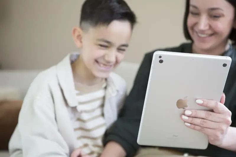 Glückliche Mutter und Sohn mit Penta Power Duo Tag auf Tablet